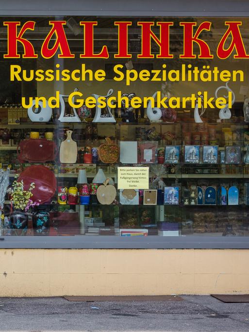 Ein älterer Mann steht mit seinem Fahrrad vor einem russischen Spezialitätengeschäft in Ludwigsburg