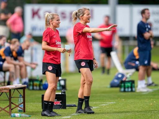 Julia Simic und Friederike Kromp geben Anweisungen und gestikulieren am Spielfeldrand.