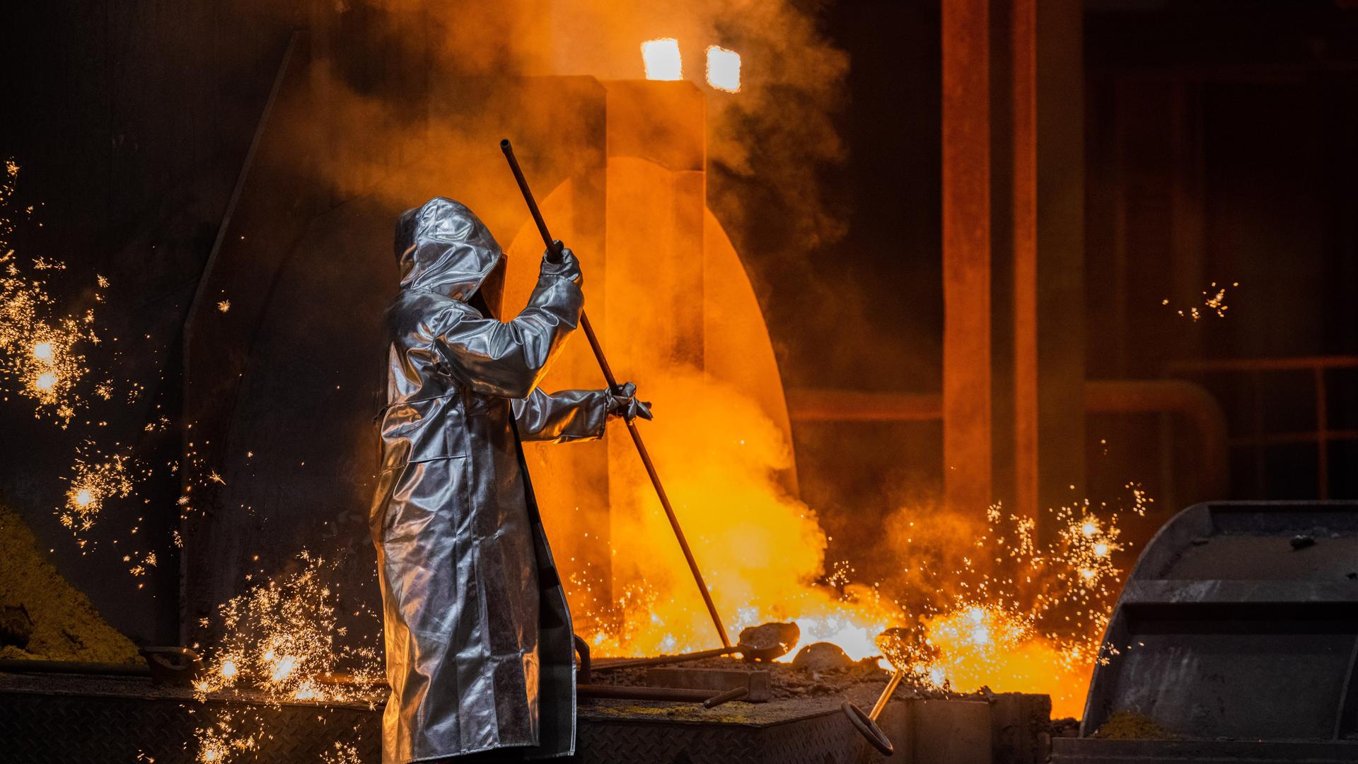 Ein Stahlarbeiter von Thyssenkrupp prüft den Roheisen am Hochofen 8 auf dem Werksgelände.