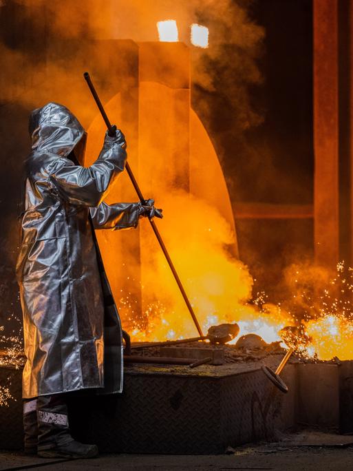 Ein Stahlarbeiter von Thyssenkrupp prüft den Roheisen am Hochofen 8 auf dem Werksgelände.