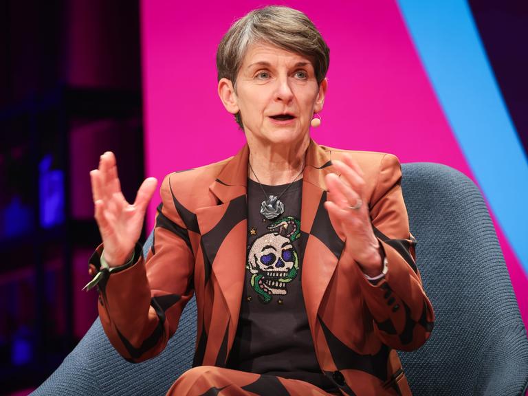 Laura McAllister, Vizepräsidentin der UEFA, spricht bei einem Podiumsgespräch vor einer rosa-blauen Wand
