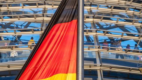  Deutschlandfahne im Abendlicht vor der Reichstagskuppel