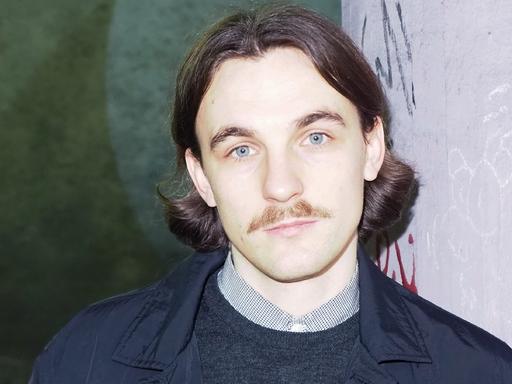 Kaleb Erdmann vor einer Betonwand