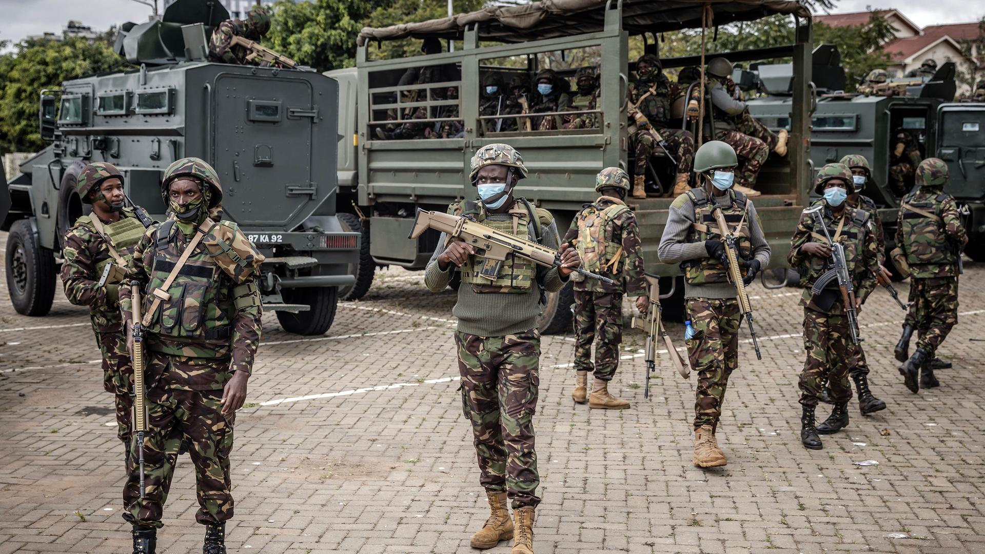 Soldaten der kenianischen Sicherheitskräfte stehen mit Waffen in der Hand vor Militärfahrzeugen in der Nähe des Stadions, wo eine Demonstration geplant ist. Soldaten der kenianischen Sicherheitskräfte stehen mit Waffen in der Hand vor Militärfahrzeugen in der Nähe des Stadions, wo eine Demonstration geplant ist.