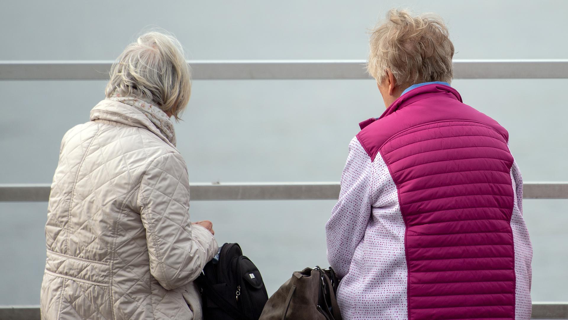 Zwei ältere Frauen sitzen auf einer Bank am Wannsee.