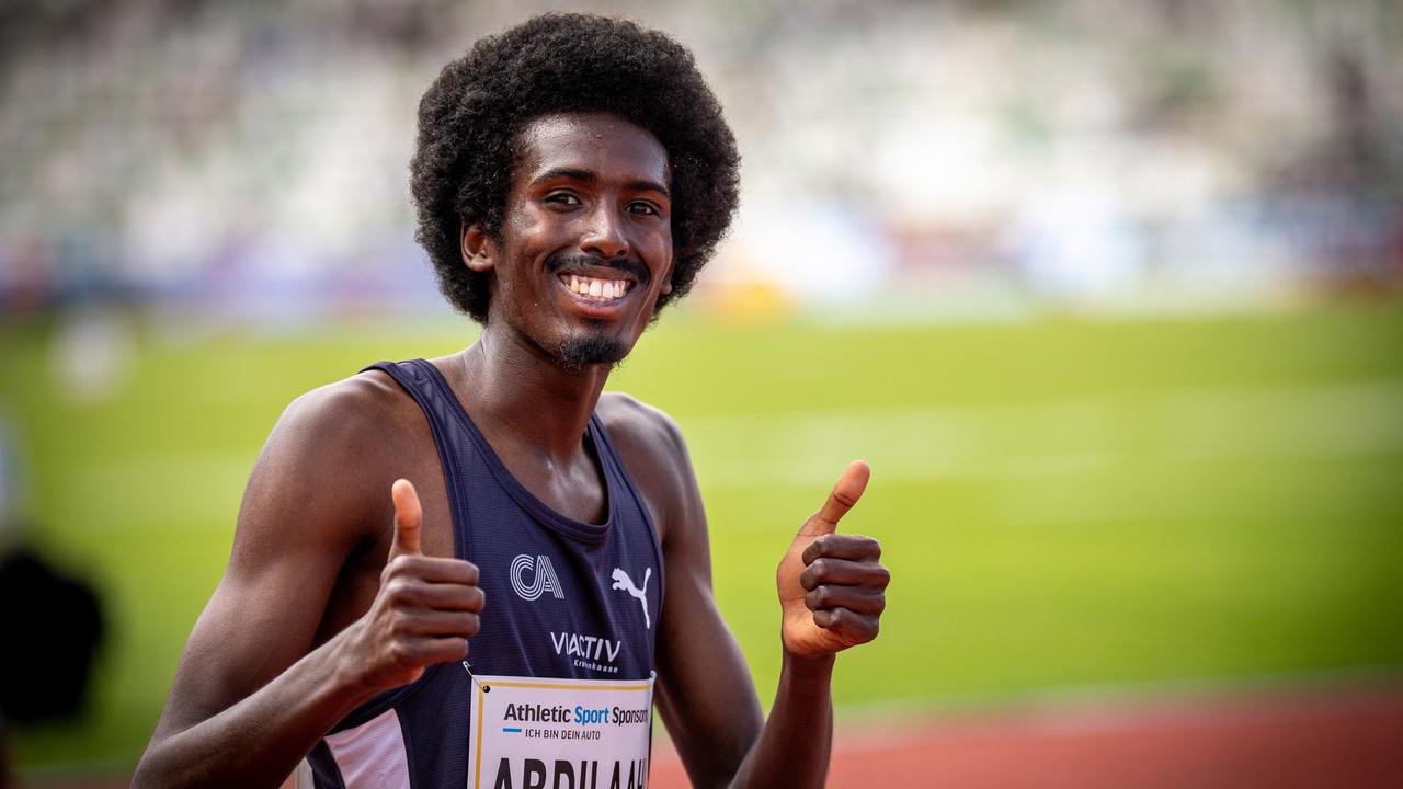 Ein Foto von Mohamed Abdilaahi. Er hat ein Trikot an, hält beide Daumen hoch und lacht in die Kamera.