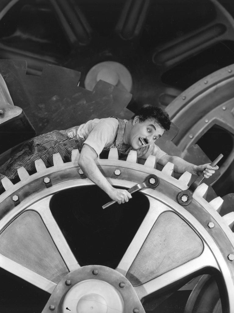 Charlie Chaplin liegt auf Zahnrädern im Stummfilm "Modern Times", 1936. Charlie Chaplin liegt auf Zahnrädern im Stummfilm "Modern Times", 1936.