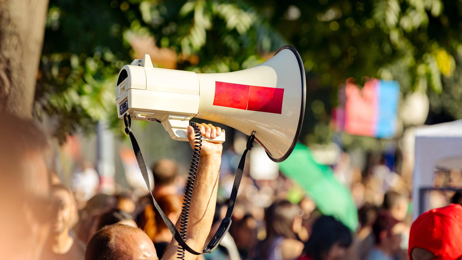 Ein Megafon wird während einer Demonstration in die Luft gehalten. 