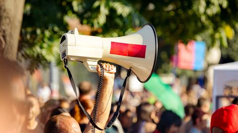 Ein Megafon wird während einer Demonstration in die Luft gehalten. 