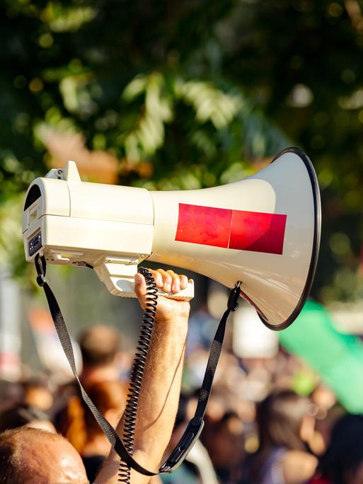 Ein Megafon wird während einer Demonstration in die Luft gehalten. 