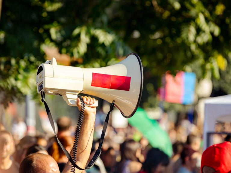 Ein Megafon wird während einer Demonstration in die Luft gehalten. 