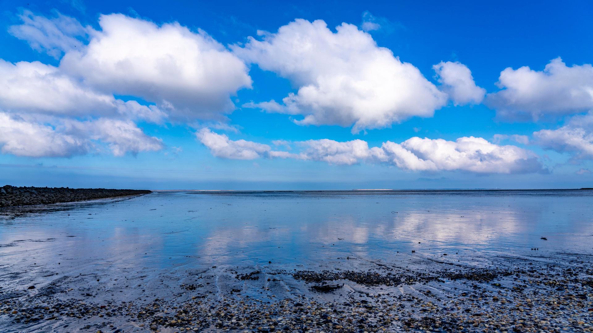 Wolken spiegeln sich im Wasser des Wattenmeers Wolken spiegeln sich im Wasser des Wattenmeers