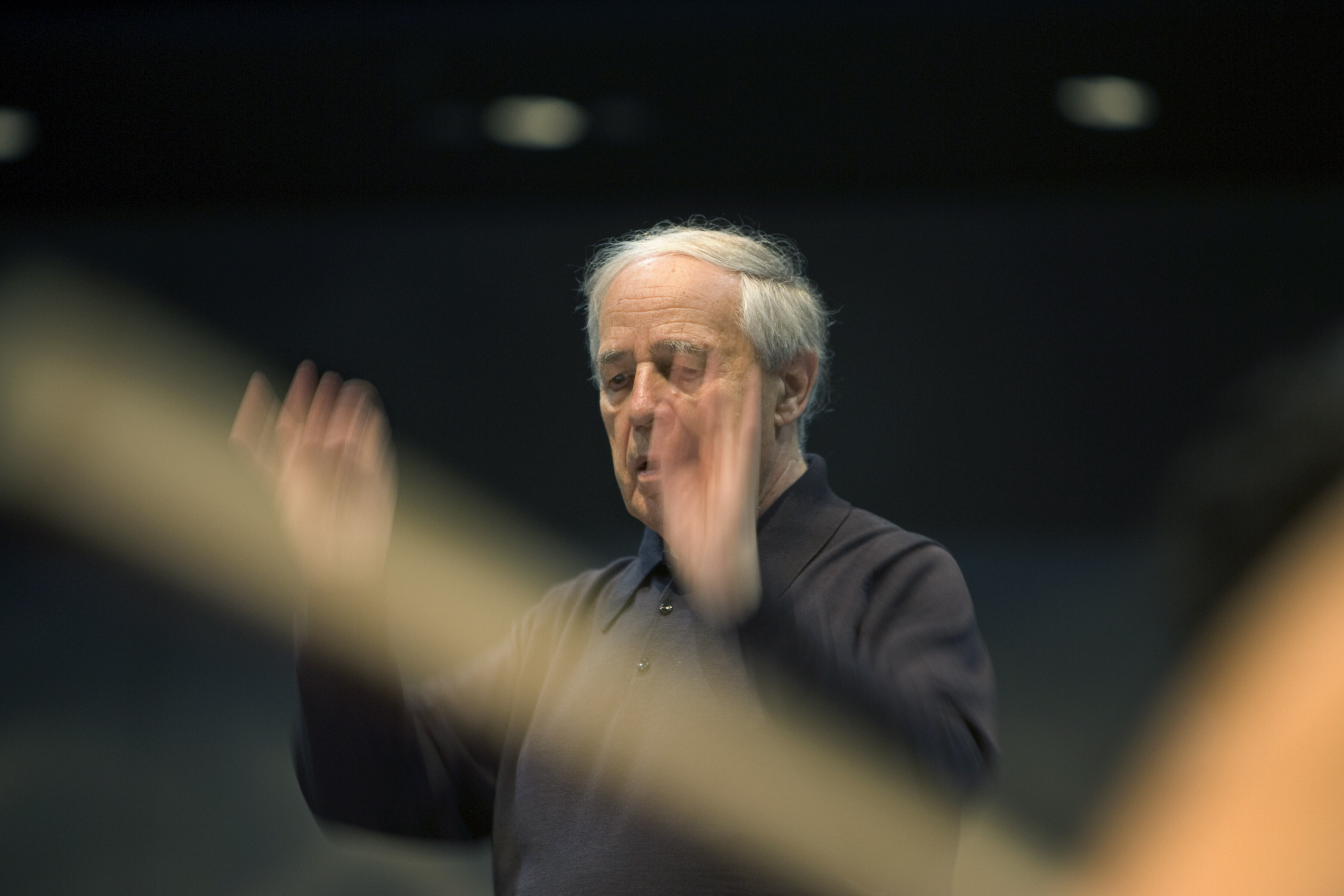 Der französische Dirigent Pierre Boulez steht in Bewegung an einem Dirigentenpult