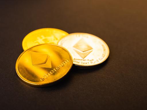 Goldene Ether-Münzen auf schwarzem Hintergrund.