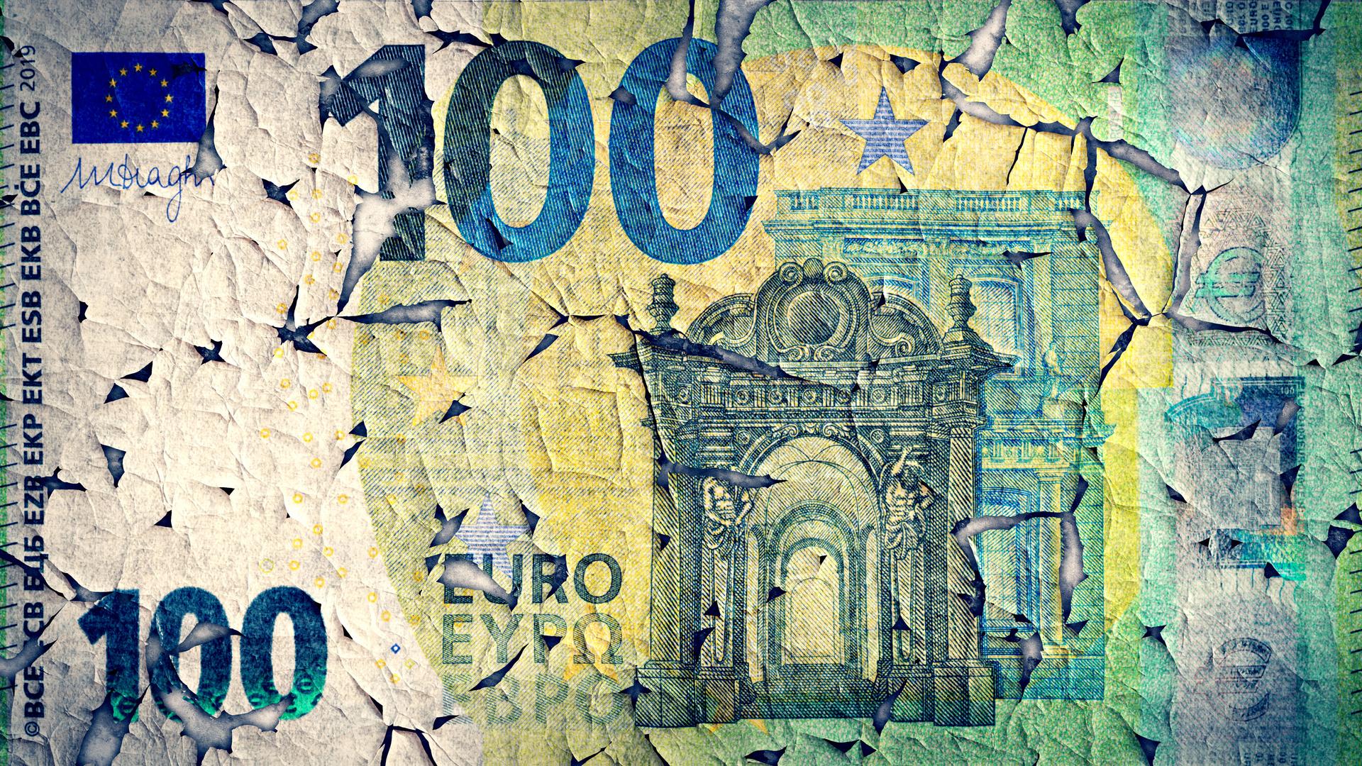 Eine verwitterte 100 Euro-Banknote löst sich langsam auf. 