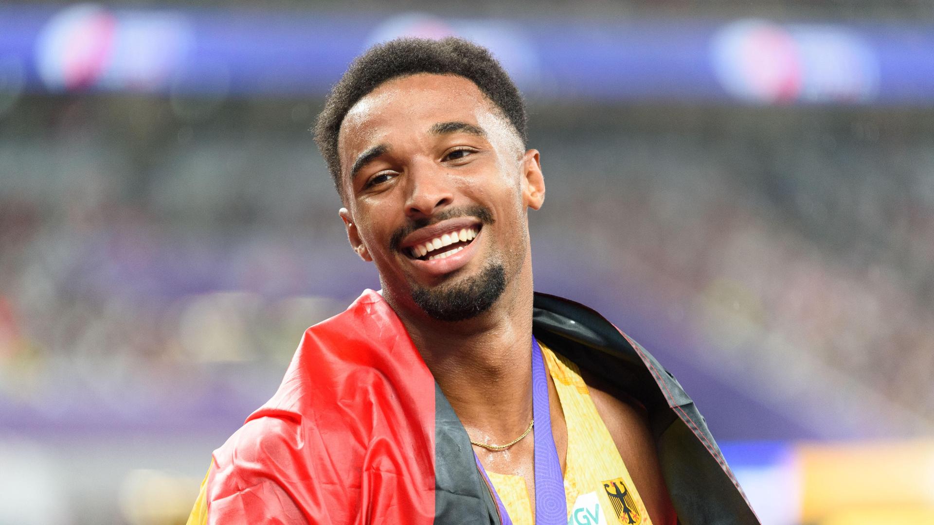 Leo Neugebauer im Stadion. Er hat eine Medaille um den Hals, eine Deutschlandfahne um die Schultern und lächelt. Er sieht glücklich aus. Leo Neugebauer im Stadion. Er hat eine Medaille um den Hals, eine Deutschlandfahne um die Schultern und lächelt. Er sieht glücklich aus.