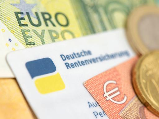 Ein Ausweis der Deutschen Rentenversicherung liegt zusammen mit Euro Banknoten Ein Ausweis der Deutschen Rentenversicherung liegt zusammen mit Euro Banknoten