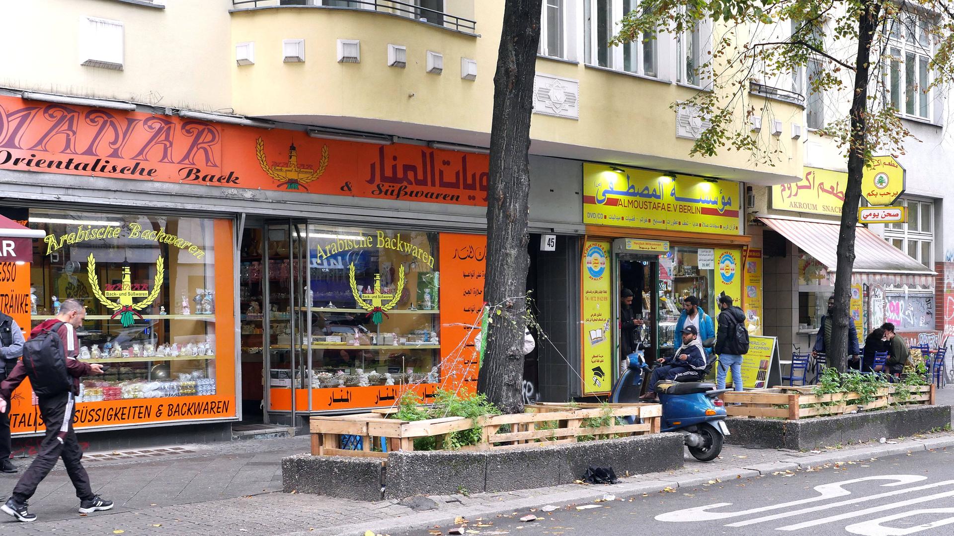 Der arabisch geprägte Teil der Berliner Sonnenallee - Menschen laufen an Geschäften mit arabischer Schrift vorbei.