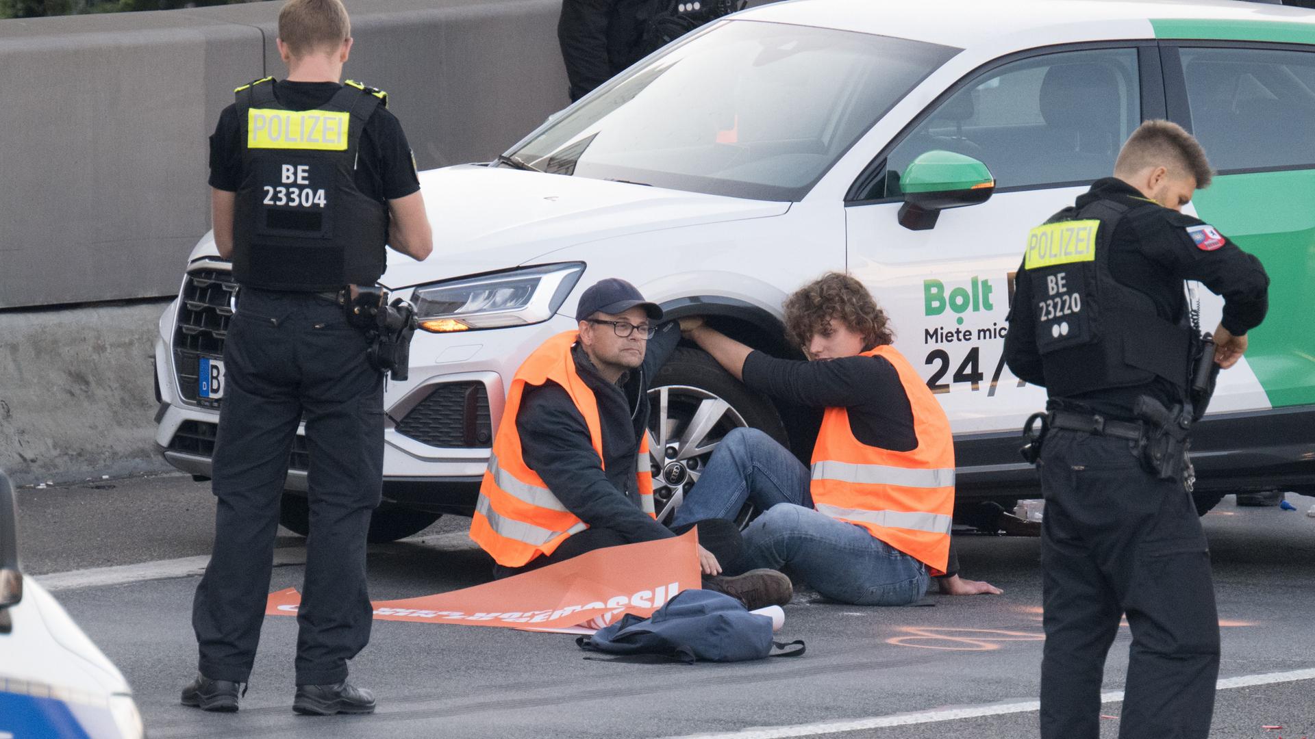 Berlin: Aktivisten haben sich während einer Straßenblockade der Klimaschutzgruppe Letzte Generation auf der A100 an einem Mietwagen festgeklebt.