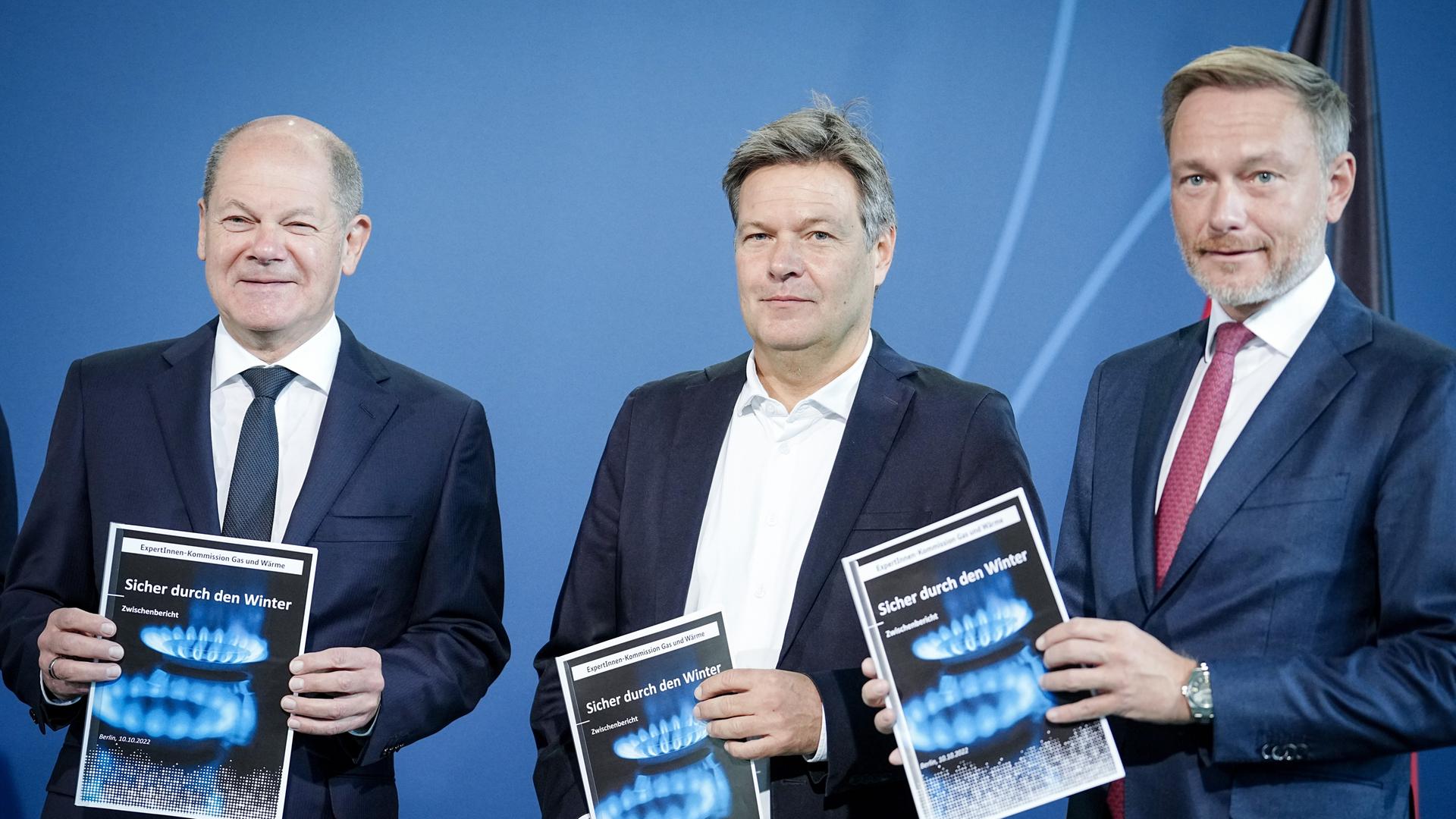 Bundeskanzler Olaf Scholz (SPD), Robert Habeck (Bündnis 90/Die Grünen), und Christian Lindner (FDP), stehen nebeneinander auf einer Bühne.