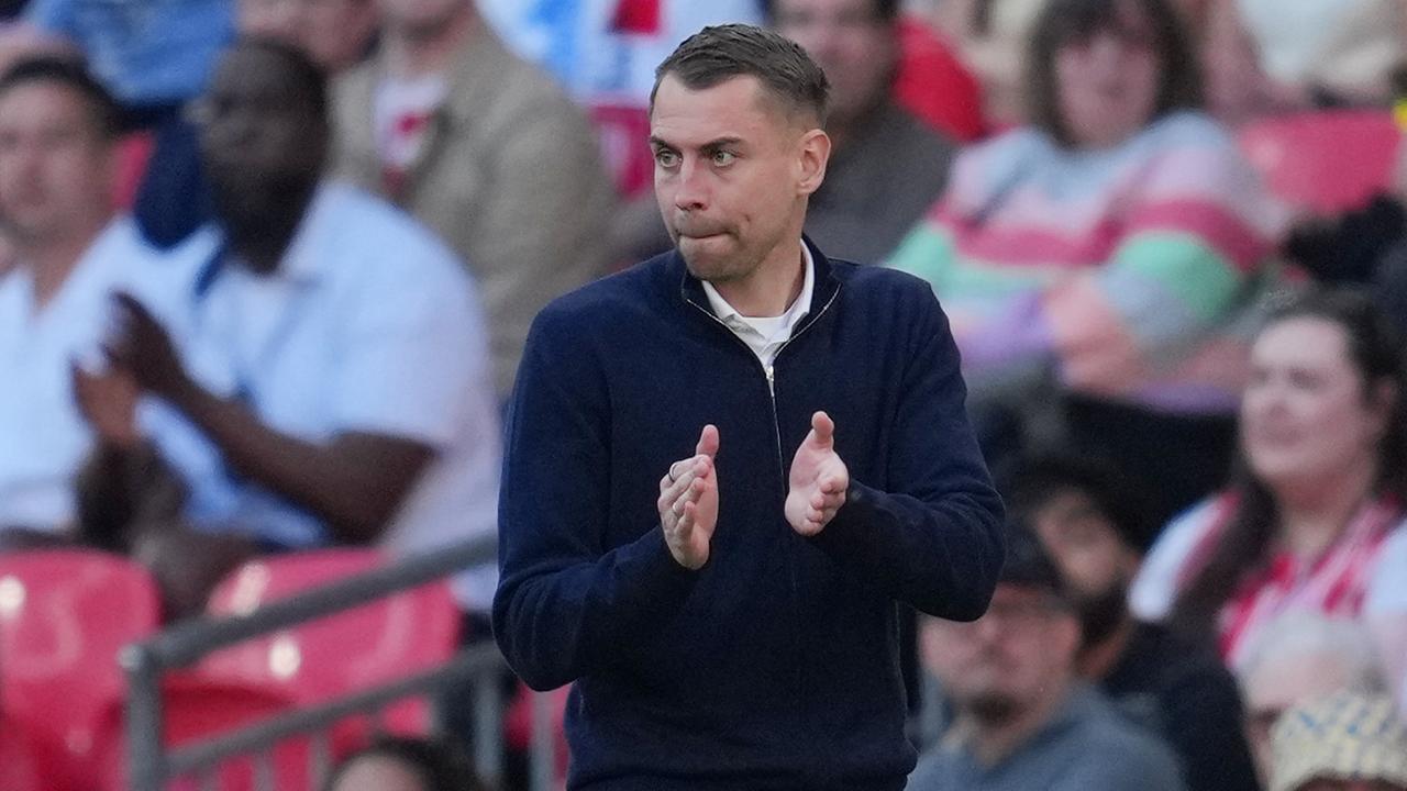 Das Bild zeigt Southampton-Coach Tonda Eckert, der vom Spielfeldrand in die Hände klatschend seine Mannschaft anfeuert. Im Hintergrund sind schemenhaft Zuschauer auf den Rängen des Stadions zu sehen.