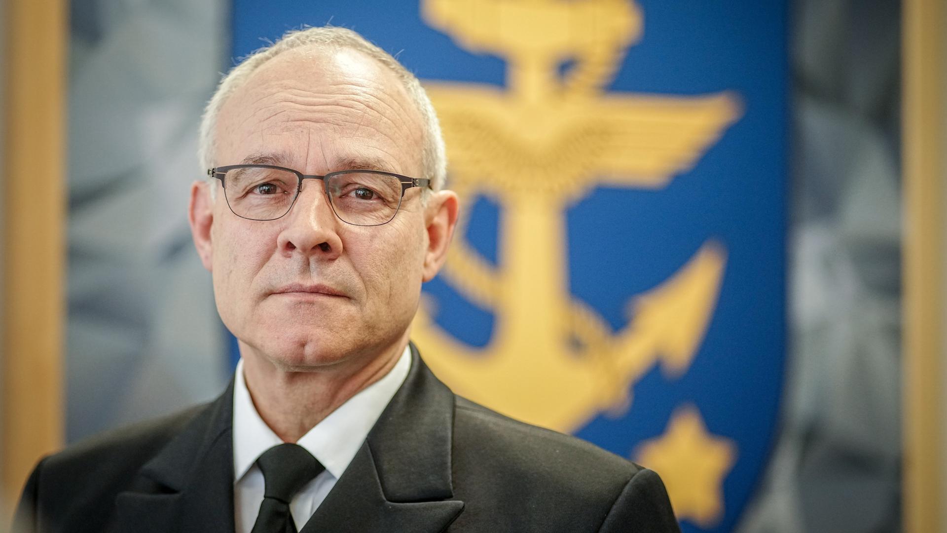 Jan Christian Kaack in seinem Büro im Verteidigungsministerium. Im Hintergrund ist ein blaues Wappen eines gelben geflügelten Ankers zu sehen, um den sich ein gelbes Seil windet. Jan Christian Kaack in seinem Büro im Verteidigungsministerium. Im Hintergrund ist ein blaues Wappen eines gelben geflügelten Ankers zu sehen, um den sich ein gelbes Seil windet.