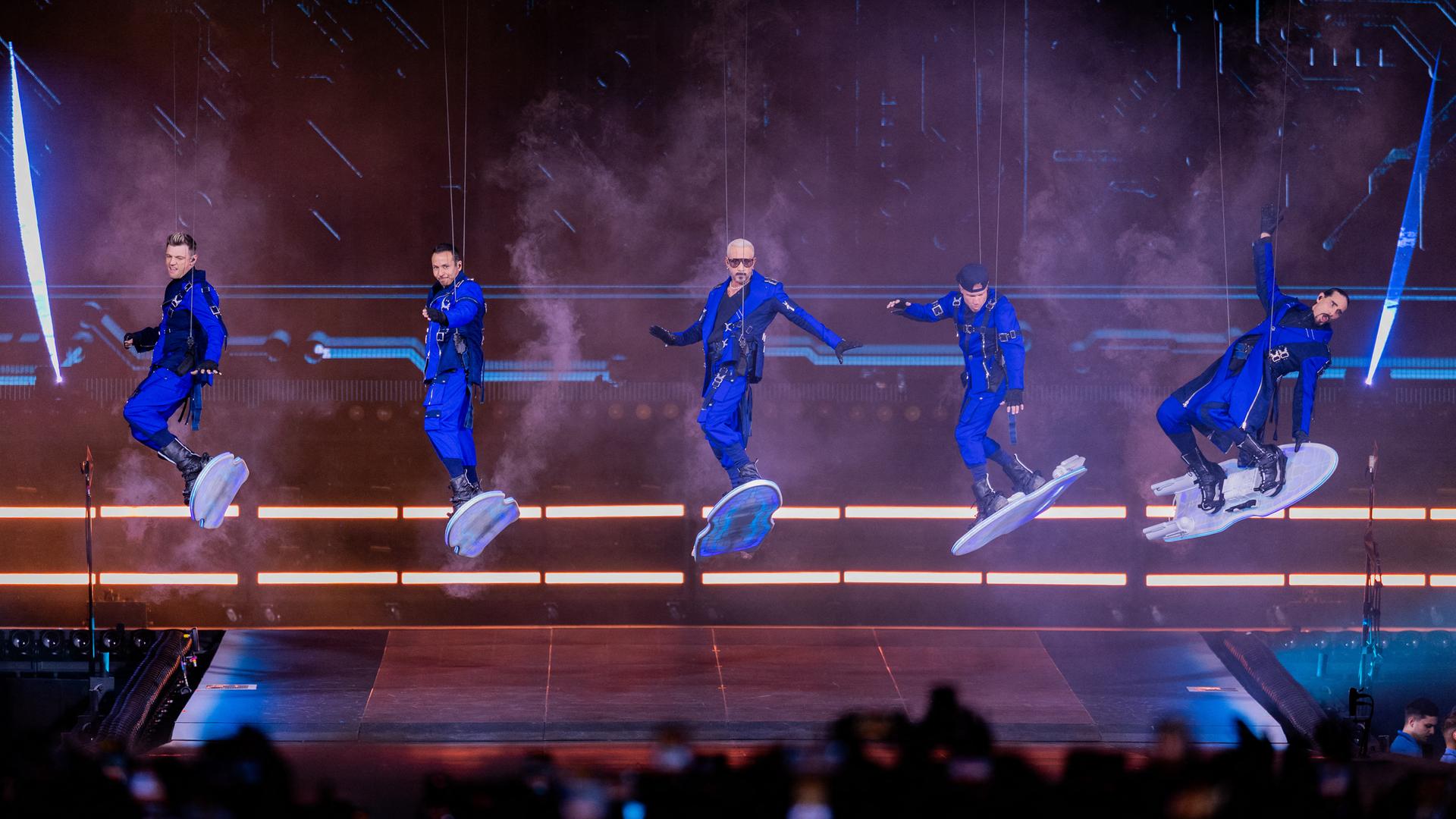 Brian Littrell, Nick Carter, Kevin Richardson, AJ Mclean und Howie Dorough von den Backstreet Boys schweben auf Hovercrafts über der Bühne