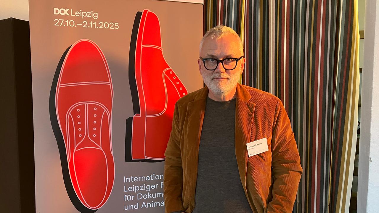 Der Leiter des Dokumetarfilm-Festivals DOK Leipzig, Christoph Terhechte, steht vor einem Plakat zur 68. Auflage des Festivals.