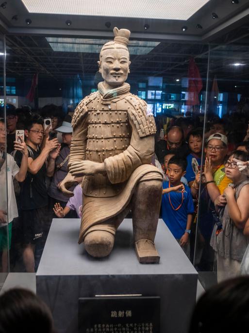 Xi’an, Provinz Shaanxi, USA: Besucher fotografieren einen Tonkrieger aus der Terrakotta-Armee im Mausoleum von Qin Shi Huang, dem ersten Kaiser Chinas Xi’an, Provinz Shaanxi, USA: Besucher fotografieren einen Tonkrieger aus der Terrakotta-Armee im Mausoleum von Qin Shi Huang, dem ersten Kaiser Chinas