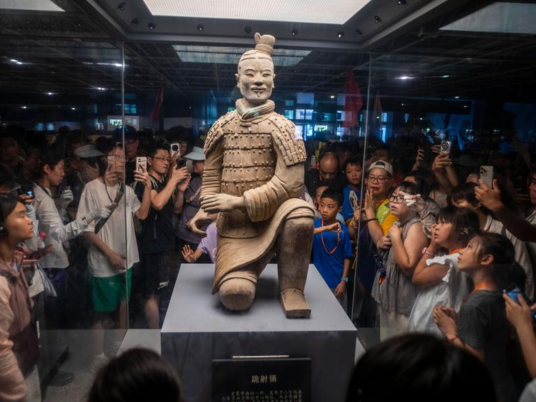 Xi’an, Provinz Shaanxi, USA: Besucher fotografieren einen Tonkrieger aus der Terrakotta-Armee im Mausoleum von Qin Shi Huang, dem ersten Kaiser Chinas Xi’an, Provinz Shaanxi, USA: Besucher fotografieren einen Tonkrieger aus der Terrakotta-Armee im Mausoleum von Qin Shi Huang, dem ersten Kaiser Chinas
