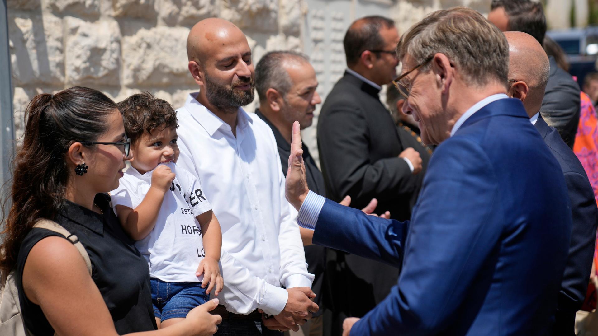 Bundesaußenminister Wadephul unterhält sich mit einer palästinensischen Familie. Die Frau trägt einen Jungen auf dem Arm, Wadephul hebt die Hand, um mit ihm abzuklatschen. Bundesaußenminister Wadephul unterhält sich mit einer palästinensischen Familie. Die Frau trägt einen Jungen auf dem Arm, Wadephul hebt die Hand, um mit ihm abzuklatschen.