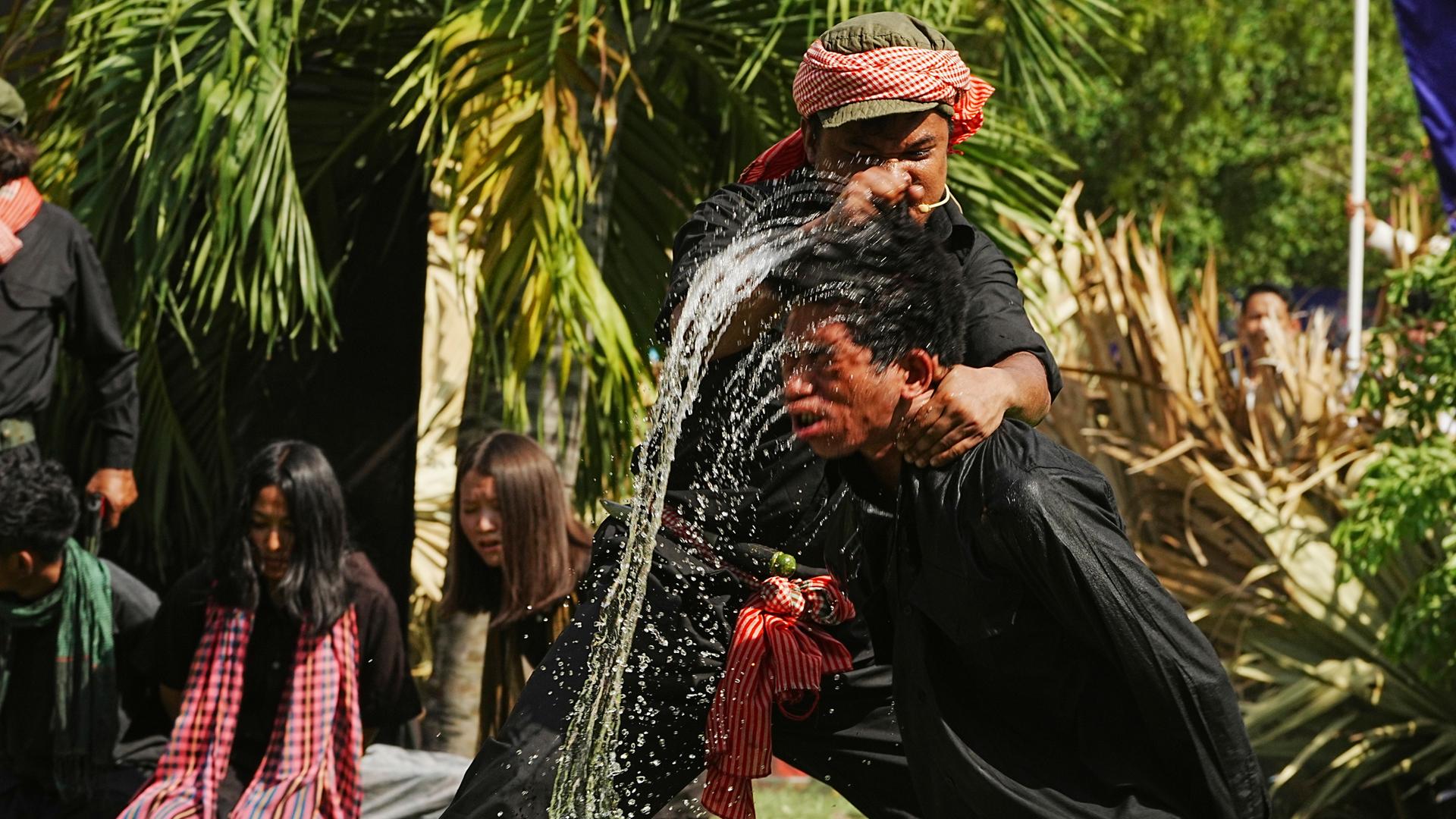 Kambodschanische Studenten der Königlichen Universität der Schönen Künste stellen eine Folterung durch Eintauchen des Kopfes in Wasser nach, die von den Roten Khmer während ihrer Schreckensherrschaft in den 1970er Jahren durchgeführt wurde. Kambodschanische Studenten der Königlichen Universität der Schönen Künste stellen eine Folterung durch Eintauchen des Kopfes in Wasser nach, die von den Roten Khmer während ihrer Schreckensherrschaft in den 1970er Jahren durchgeführt wurde.