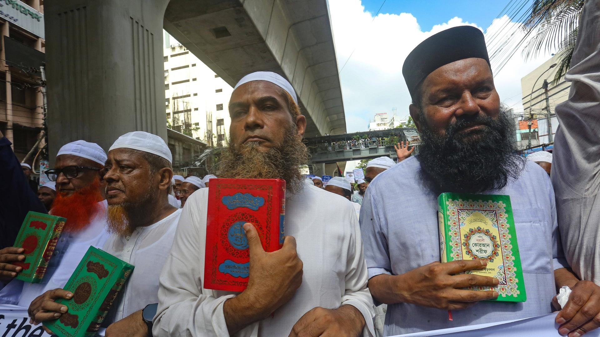 Männer mit Bart halten den Koran in den Händen bei einer Protestkundgebung in Dhaka gegen die Koranverbrennungen in Schweden.  