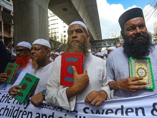 Männer mit Bart halten den Koran in den Händen bei einer Protestkundgebung in Dhaka gegen die Koranverbrennungen in Schweden.  