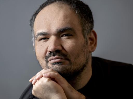 Dinçer Güçyeter, ein Mann Mitte vierzig mit Halbglatze und Drei-Tage-Bart, schaut in die Kamera