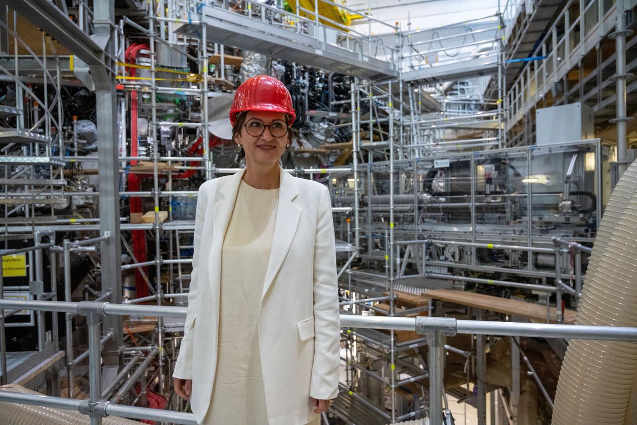 Bundesforschungsministerin Bettina Stark-Watzinger (FDP) ist vor Baugerüsten rund um eine technische Anlage zu sehen.