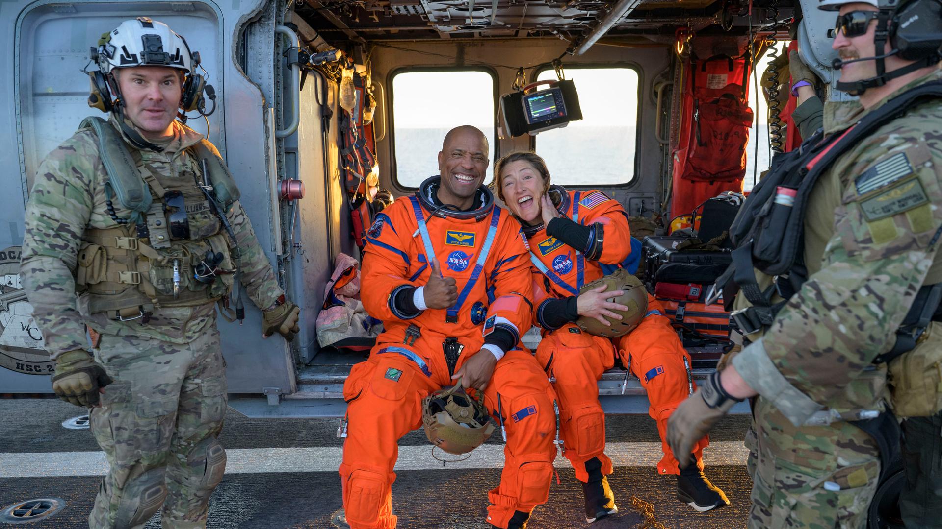 Auf diesem von der NASA zur Verfügung gestellten Foto sitzen die Astronauten Victor Glover und Christina Koch auf einem MH-60 Seahawk der Navy auf dem Flugdeck der USS John P. Murtha und lachen. Auf diesem von der NASA zur Verfügung gestellten Foto sitzen die Astronauten Victor Glover und Christina Koch auf einem MH-60 Seahawk der Navy auf dem Flugdeck der USS John P. Murtha und lachen.