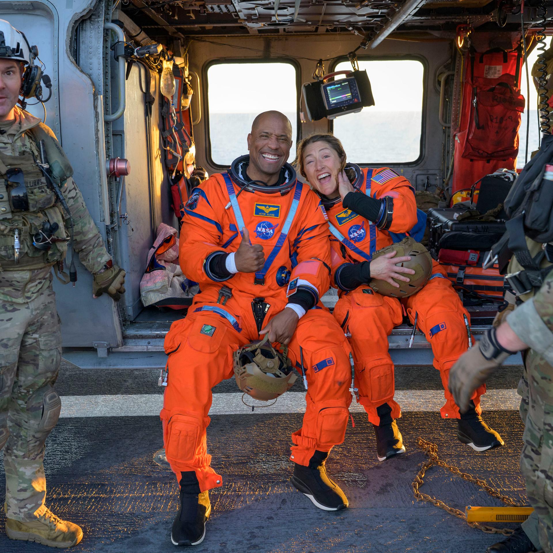 Auf diesem von der NASA zur Verfügung gestellten Foto sitzen die Astronauten Victor Glover und Christina Koch auf einem MH-60 Seahawk der Navy auf dem Flugdeck der USS John P. Murtha und lachen.