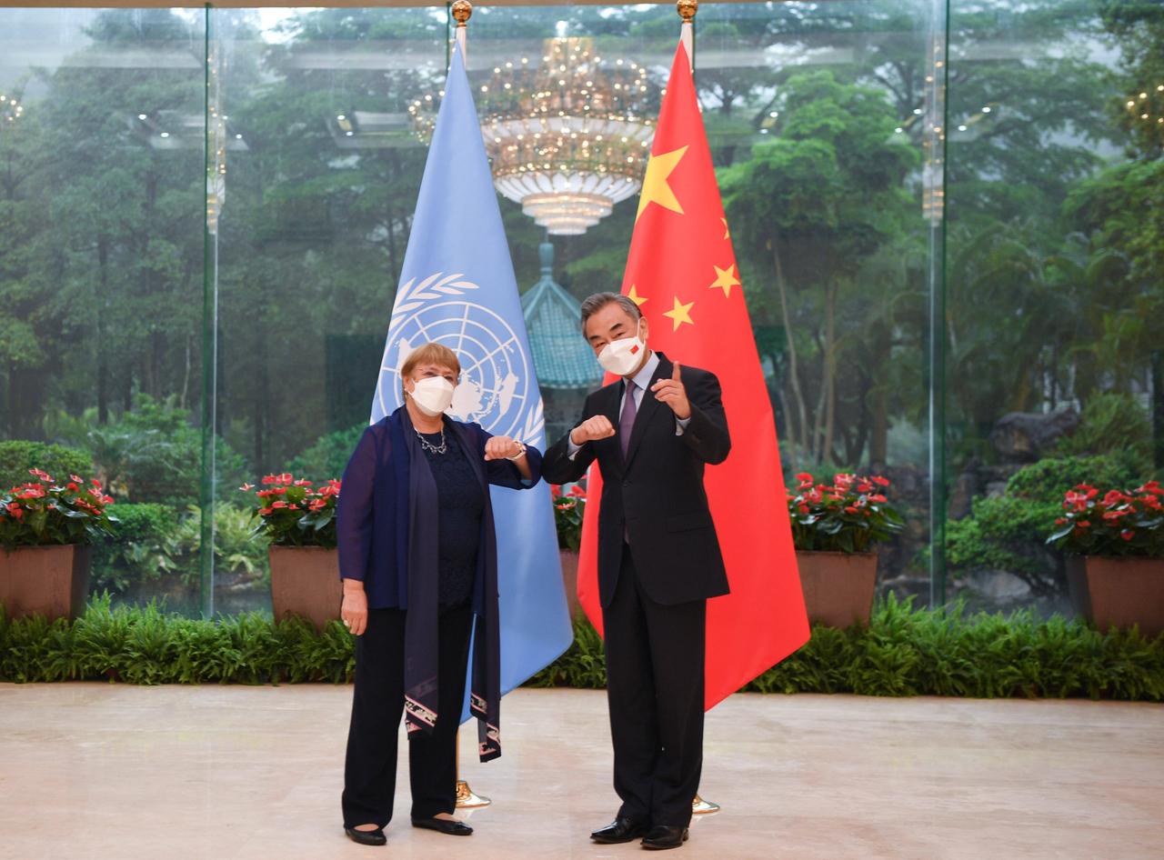 Michelle Bachelet steht links neben Wang Yi vor einer UN- und einer chinesischen Flagge. 