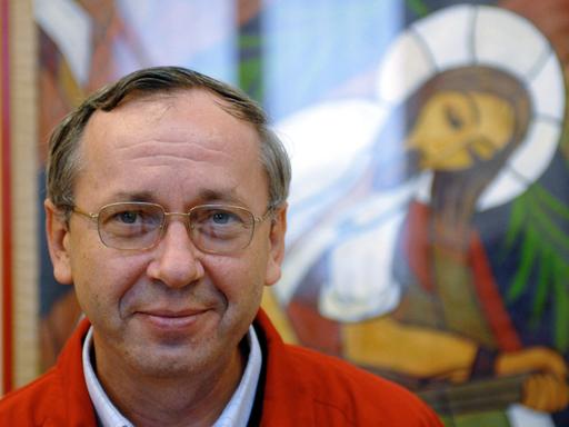 Marko Rupnik vor einem seiner Mosike, das eine Christusfigur mit Heiligenschein zeigt