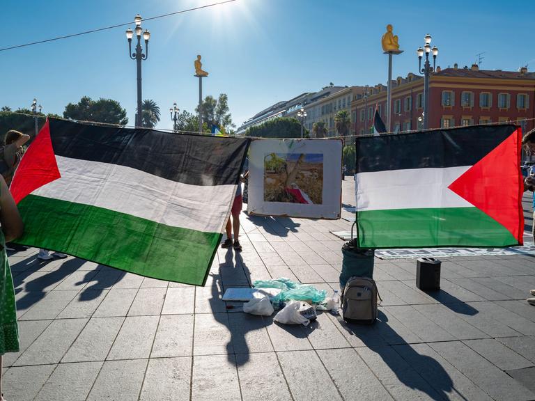 Während einer Demonstration in Nizza werden von zwei Demonstranten zwei Palästina-Flaggen aufgespannt.