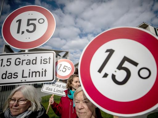 Demonstration vor dem Kanzleramt in Berlin: Mehrere Frauen halten Schilder, auf denen die Einhaltung des 1,5-Grad-Klima-Ziels gefordert wird. 