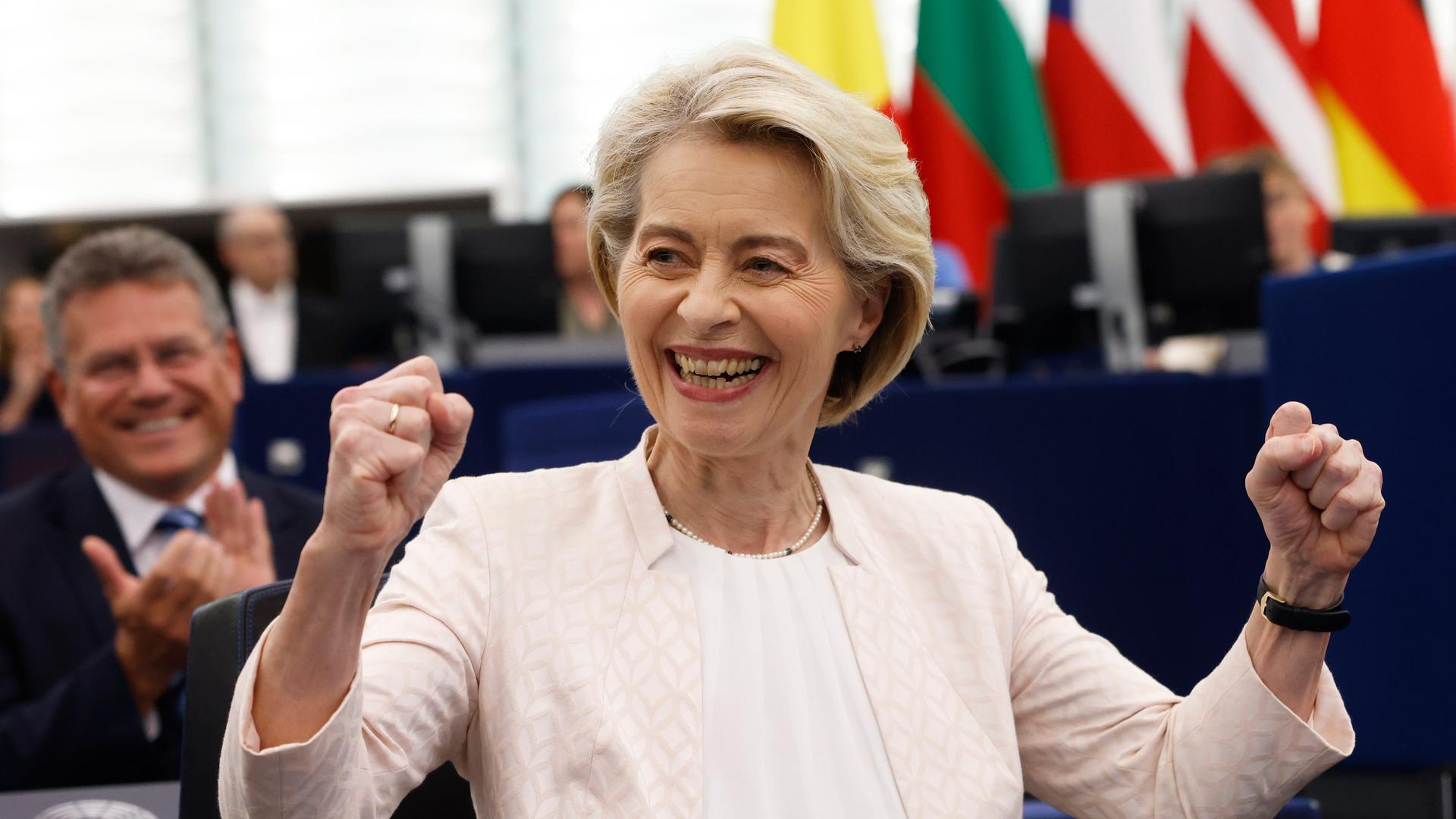 Ursula von der Leyen lächeln und die Fäuste gehoben, nachdem sie zur EU-Kommissionspräsidentin wiedergewählt worden ist. 