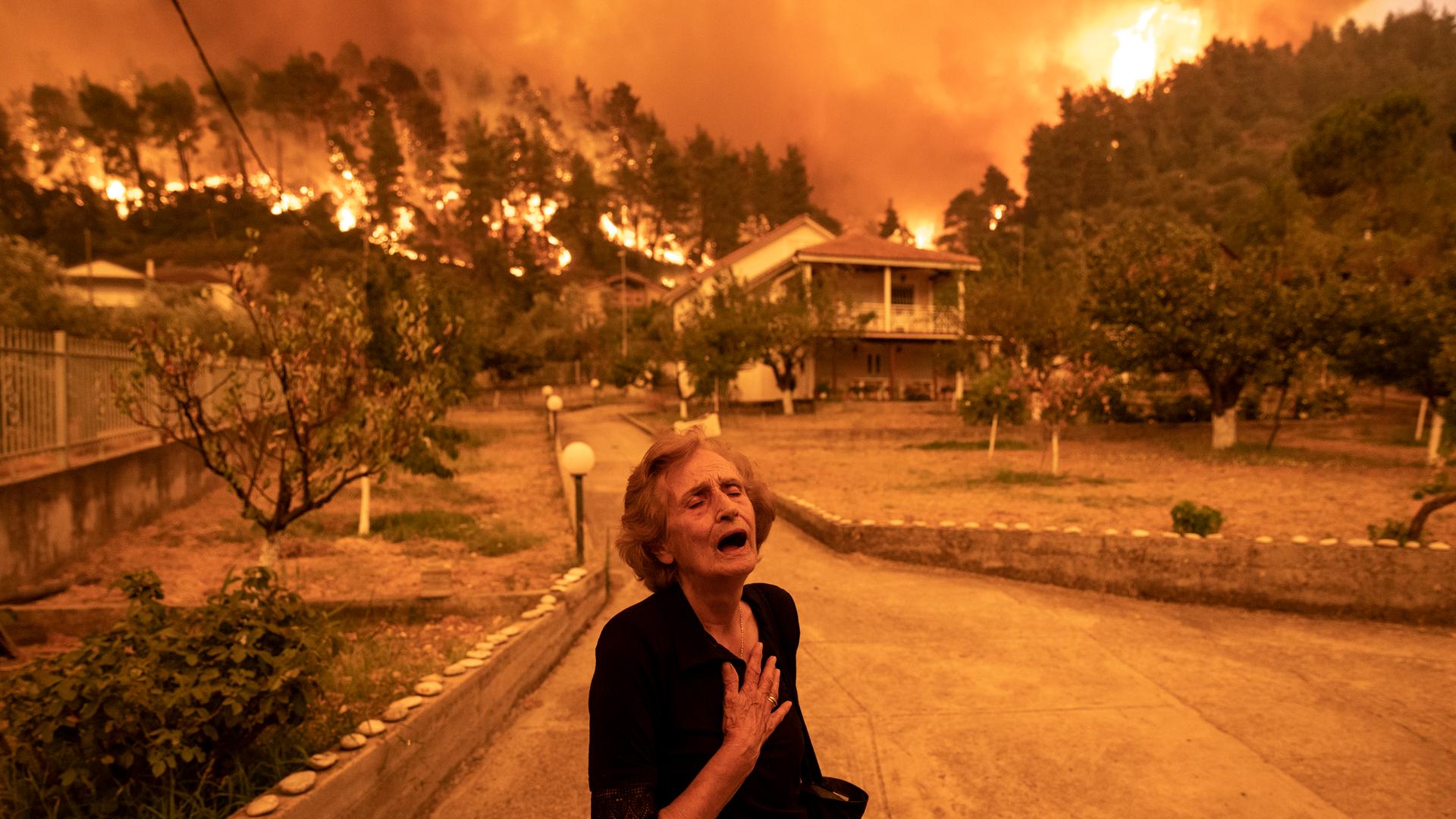 Das Bild des Bloomberg-Fotografen Konstantinos Tsakalidis zeigt Kritsiopi Panayiota (81), als sich der Waldbrand am 08.08.2021 ihrem Haus im Dorf Gouves auf der Insel Evia nähert. Das Bild des Bloomberg-Fotografen Konstantinos Tsakalidis zeigt Kritsiopi Panayiota (81), als sich der Waldbrand am 08.08.2021 ihrem Haus im Dorf Gouves auf der Insel Evia nähert.