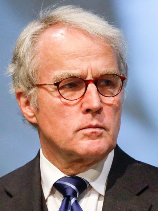 Rüdiger von Fritsch, das weiße Haar gescheitelt, mit Brille, Sakko und Krawatte, hat den Blick ernst zur Seite gewandt.