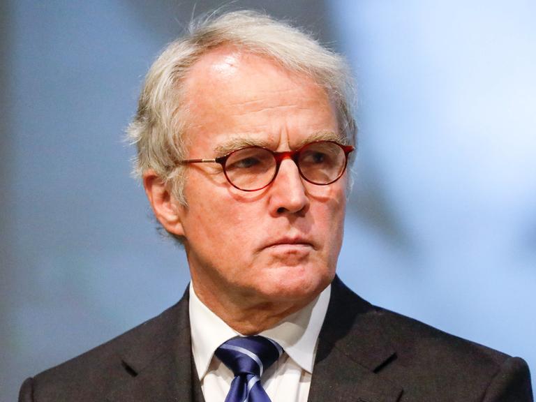 Rüdiger von Fritsch, das weiße Haar gescheitelt, mit Brille, Sakko und Krawatte, hat den Blick ernst zur Seite gewandt.