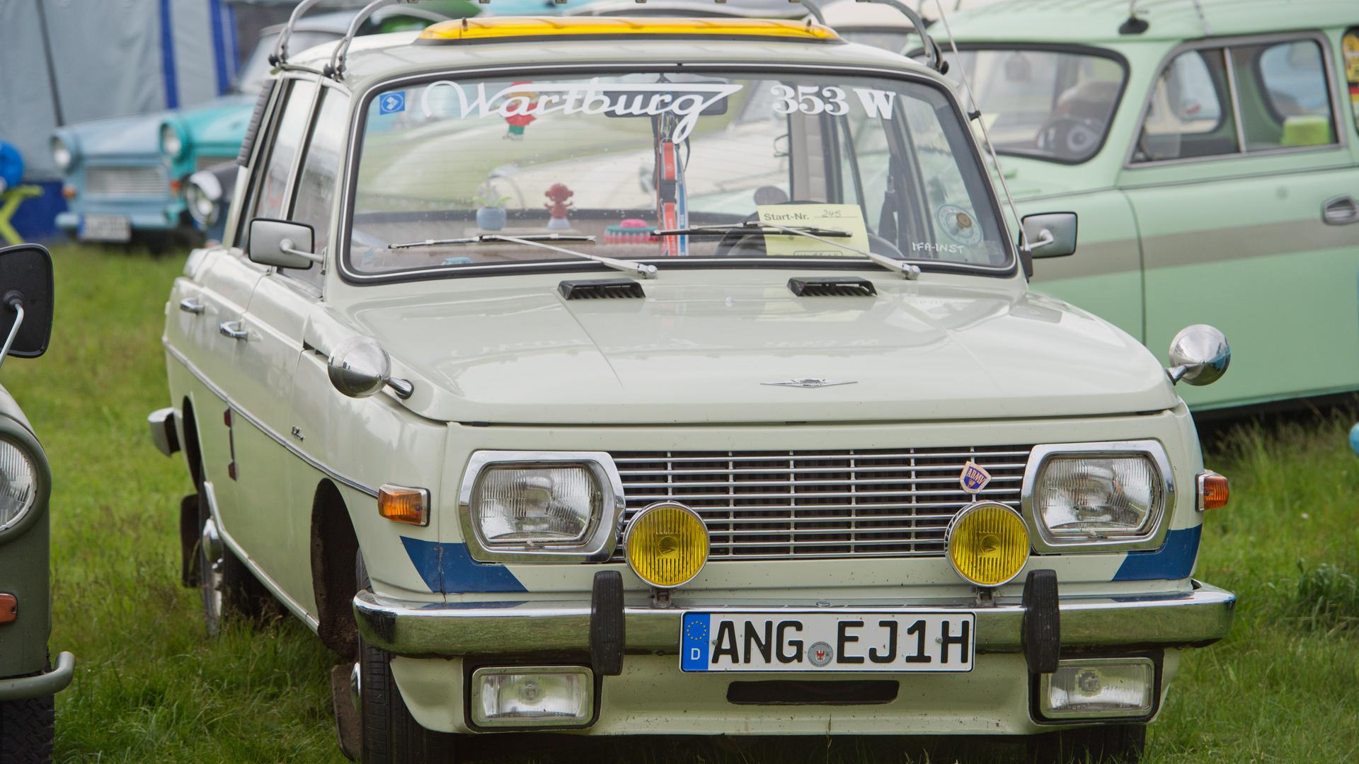 Ein Wartburg 353 W (W = Weiterentwicklung) steht auf einer Wiese zusammen mit anderen Autos. Ein Wartburg 353 W (W = Weiterentwicklung) steht auf einer Wiese zusammen mit anderen Autos.