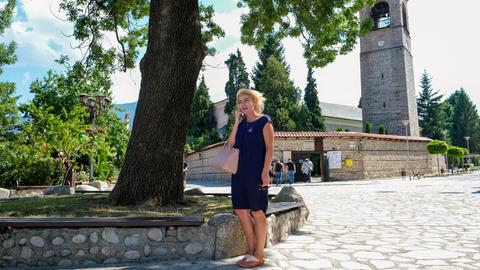 Tanya Stancheva. Eine junge Frau steht auf einem Platz und telefoniert. 