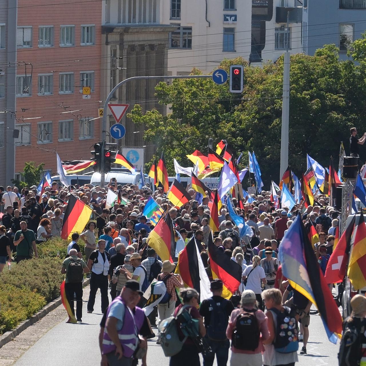 Teilnehmer einer Demonstration versammeln sich. Viele tragen Deutschlandfahnen