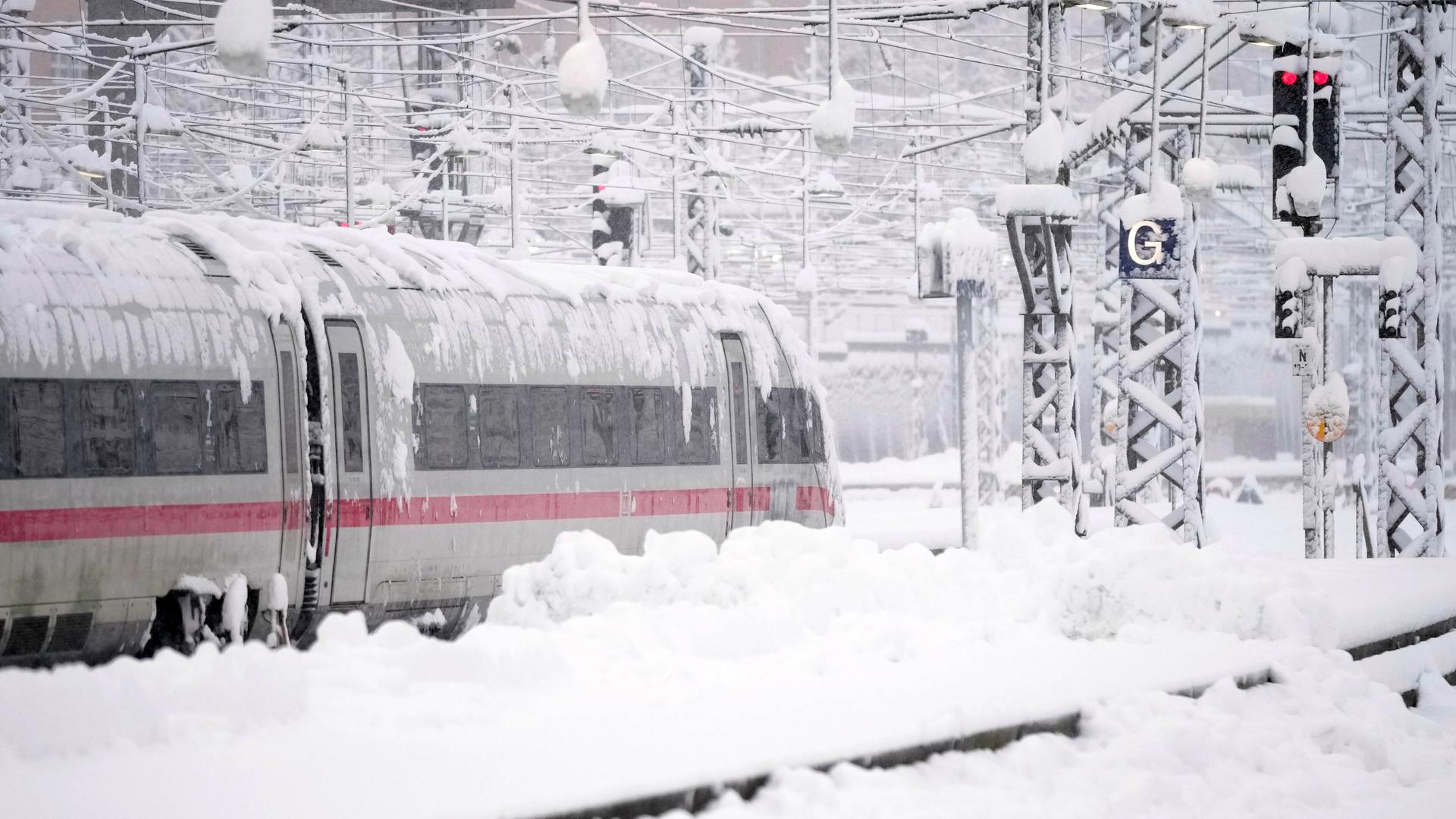 Ein ICE steht nach starkem Schneefall am Hauptbahnhof München.